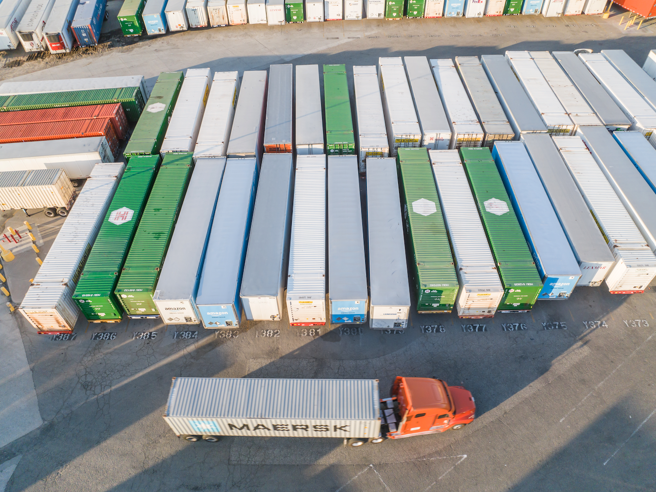 Distribution warehouse lot with lots of tractor trailers parked tightly together