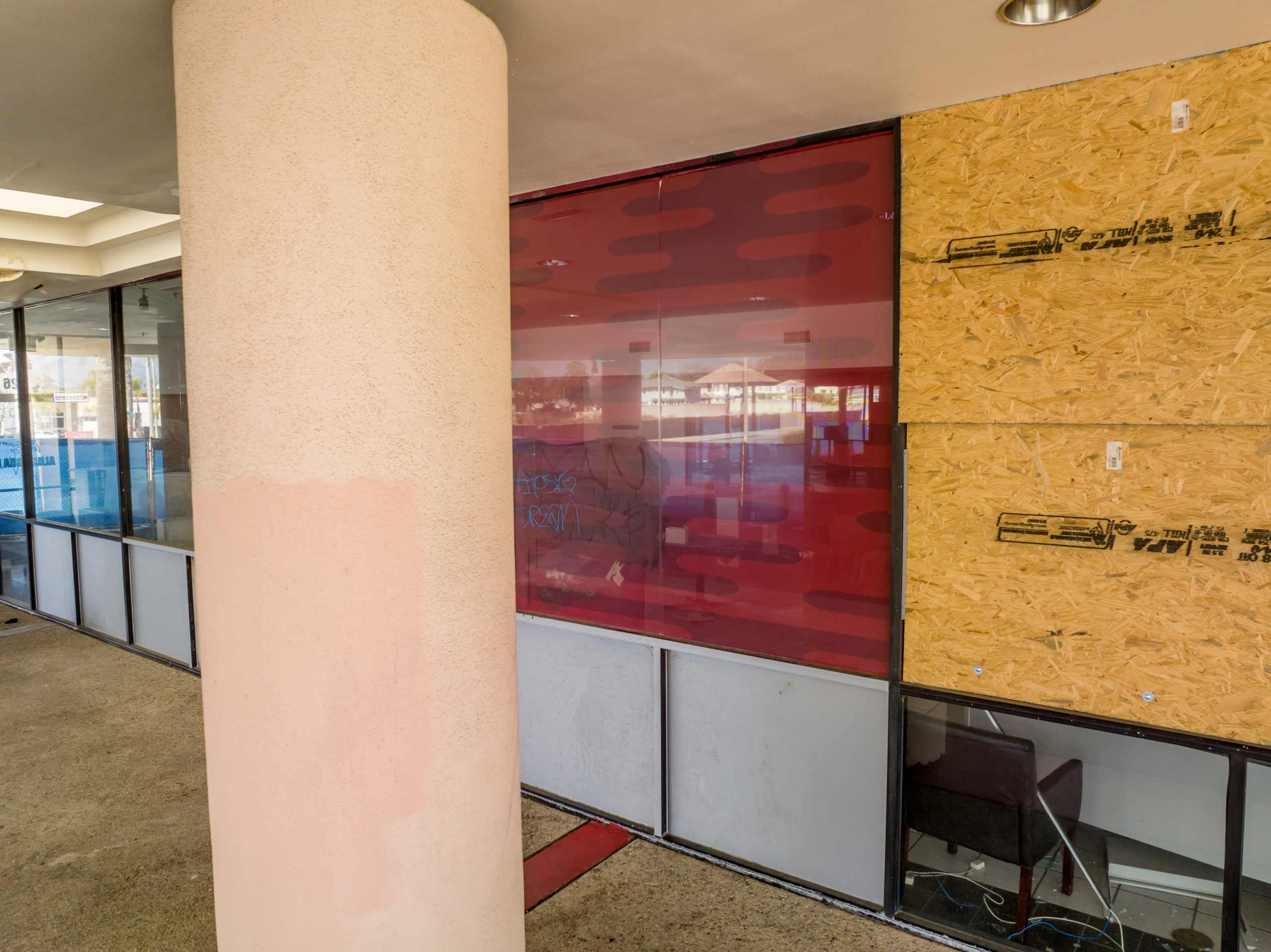 former car dealership with boarded up windows